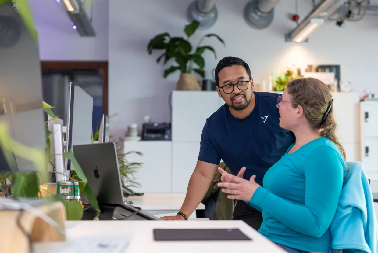 Twee collega's werken samen achter een laptop op kantoor