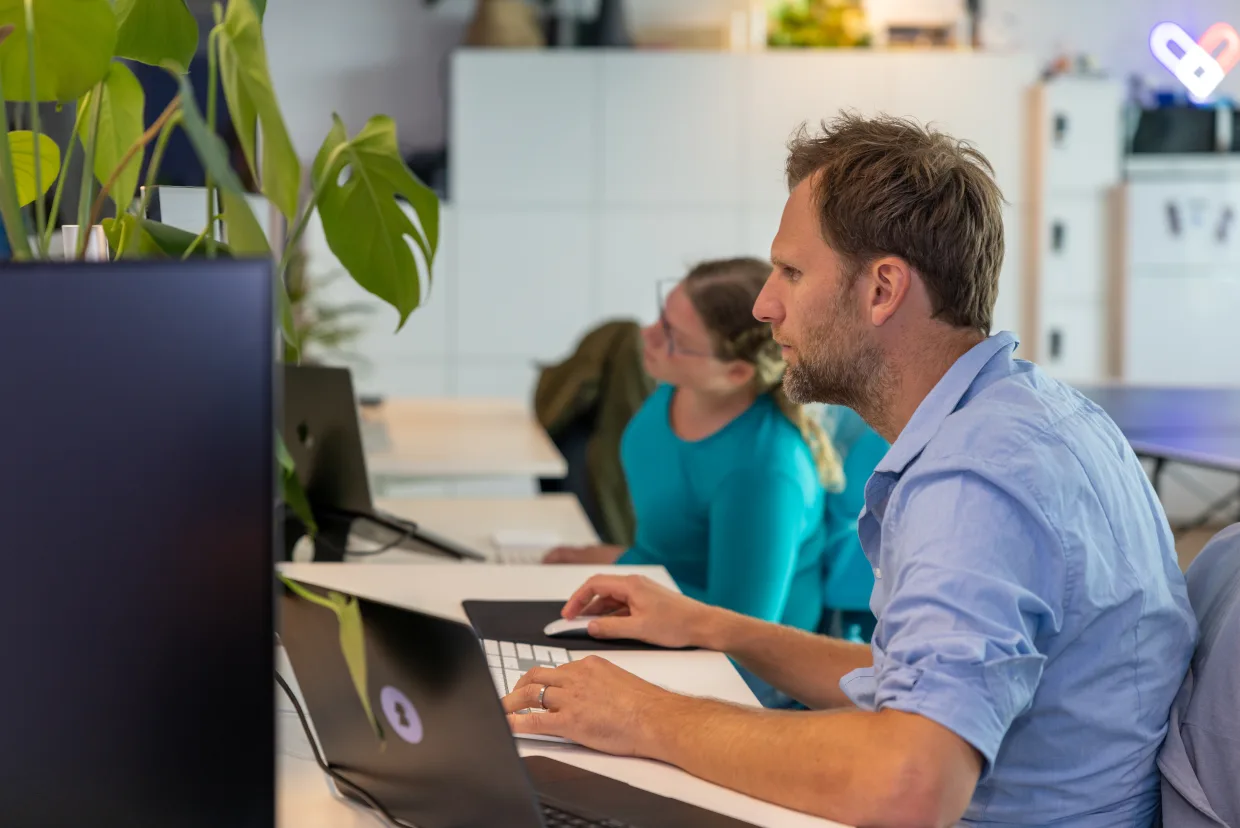 Twee collega's werken samen achter een laptop